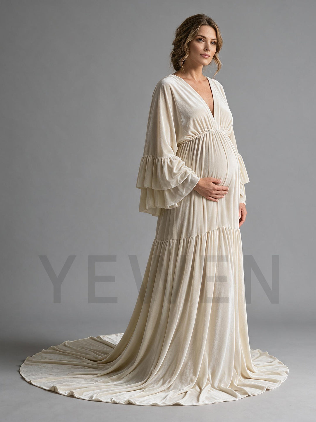 Side profile of a cream velvet maternity photoshoot dress showing the flowing silhouette.