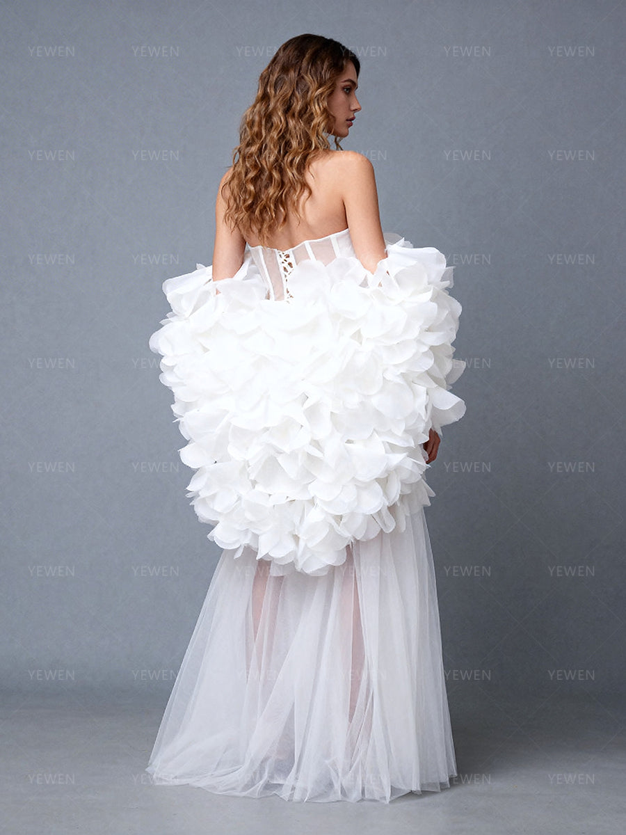 Back view of a model wearing a white 2-piece evening gown with a 3D floral cape and sheer tulle skirt.