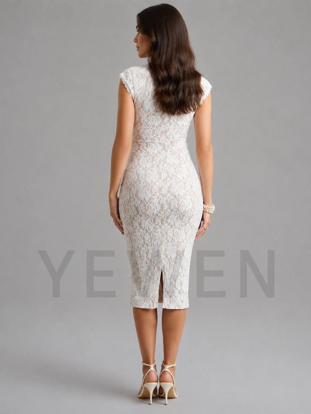 A woman shown from the back wearing a fitted sleeveless lace midi dress in a warm off-white/ivory tone, paired with beige high-heeled sandals, against a plain gray studio background.