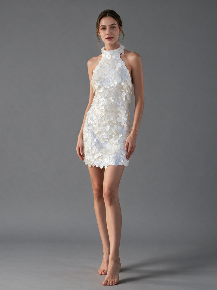 Woman wearing a white paillette sequin halter mini evening dress, front view.