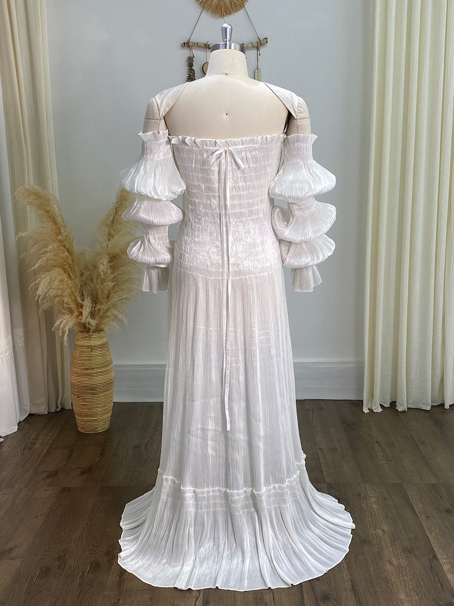 Back view of white pleated maternity dress featuring long sleeves and elegant details for photo sessions