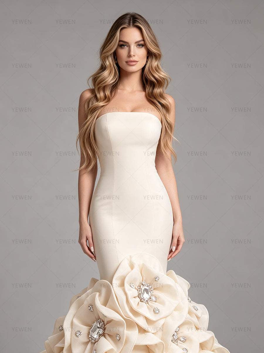Front top view of an elegant champagne bridal dress featuring a minimalist strapless top and a dramatic floral and crystal embellished skirt.