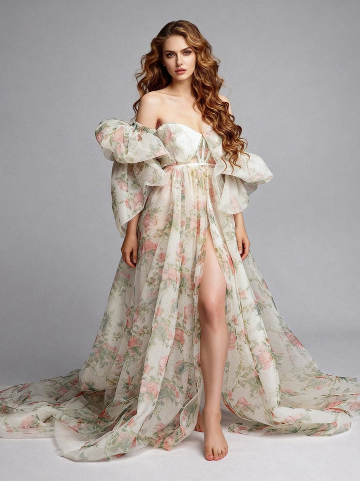 Side view of a white floral off-shoulder maternity photoshoot gown, highlighting the voluminous puff sleeves, high side slit, and flowing train, set in a studio.