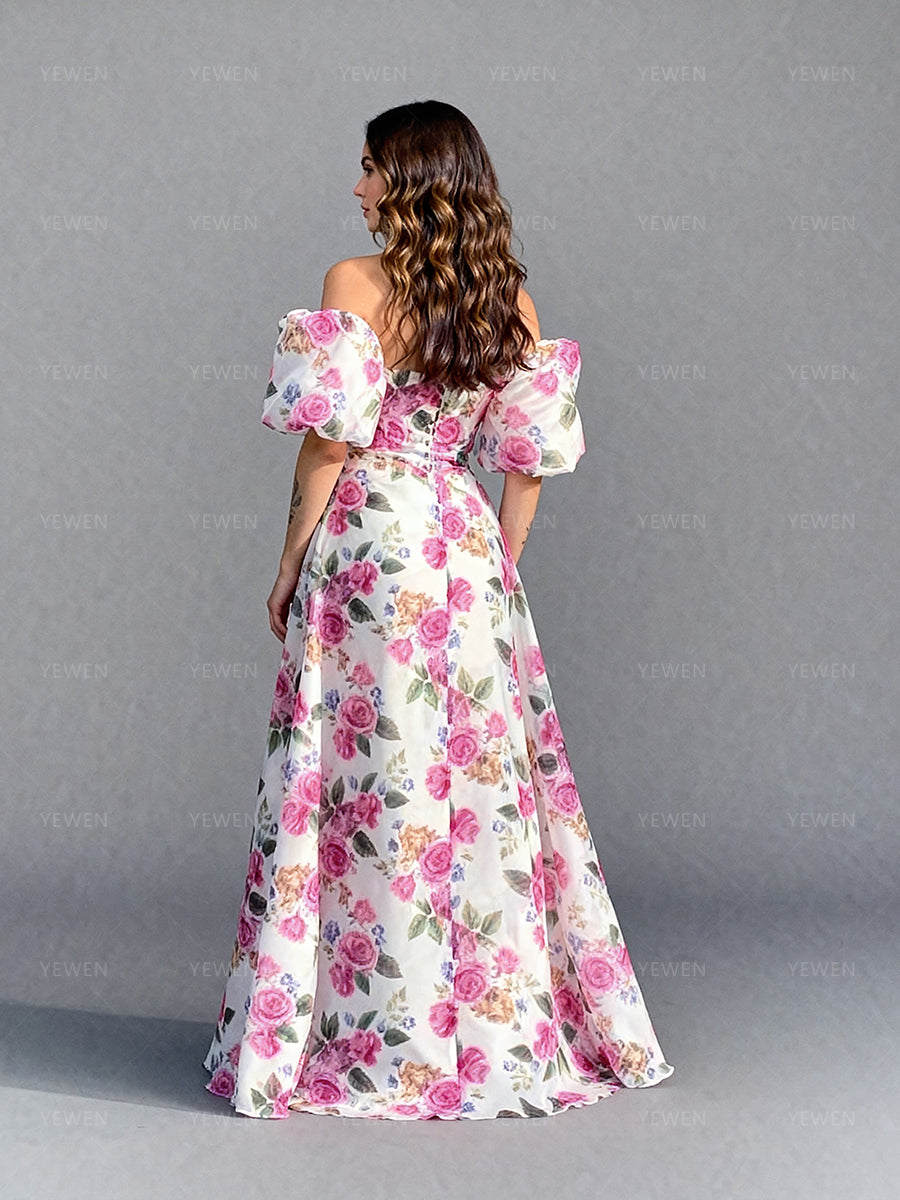 Back view of a model wearing a floral organza elegant outdoor photoshoot dress with a fitted bodice and flowing skirt.