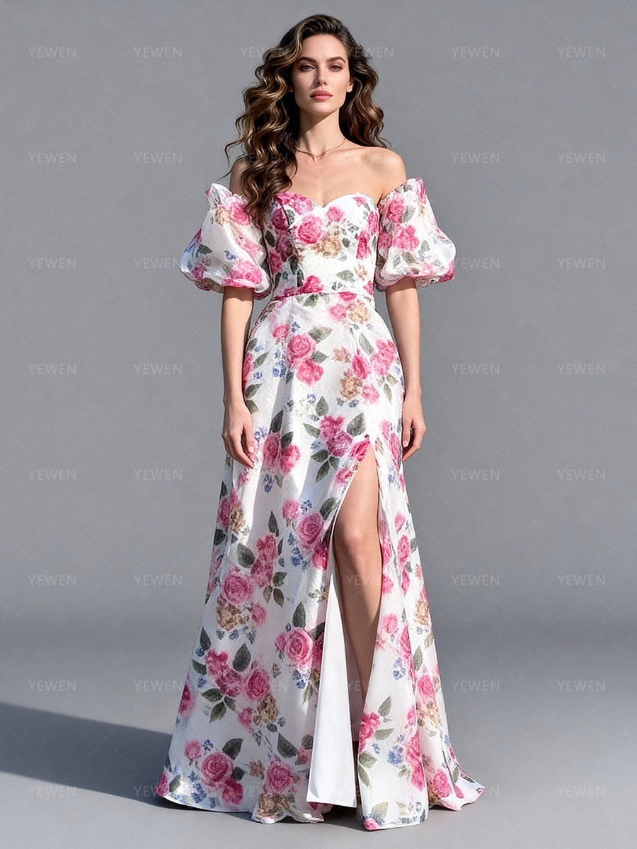Full front view of a model wearing a floral organza elegant outdoor photoshoot dress with off-shoulder puff sleeves and a high slit.