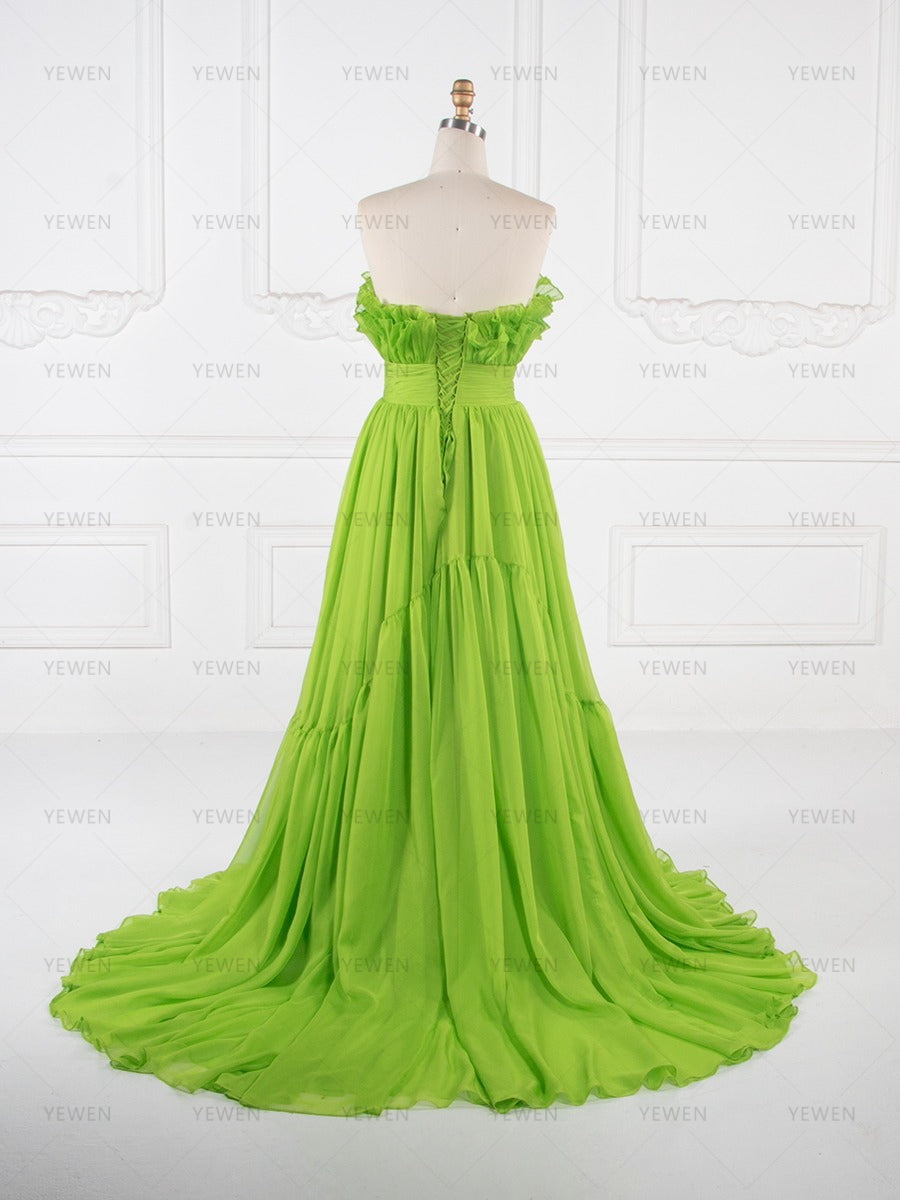 Back view of a lime green ruffle evening gown with a fitted bodice and flowing pleated skirt displayed on a mannequin.