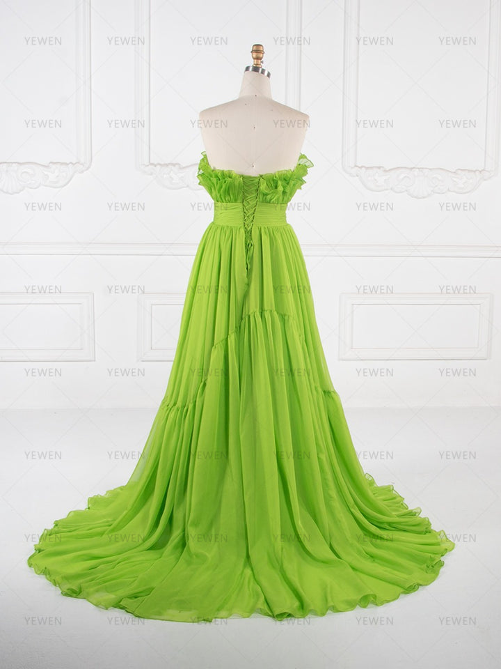 Back view of a lime green ruffle evening gown with a fitted bodice and flowing pleated skirt displayed on a mannequin.