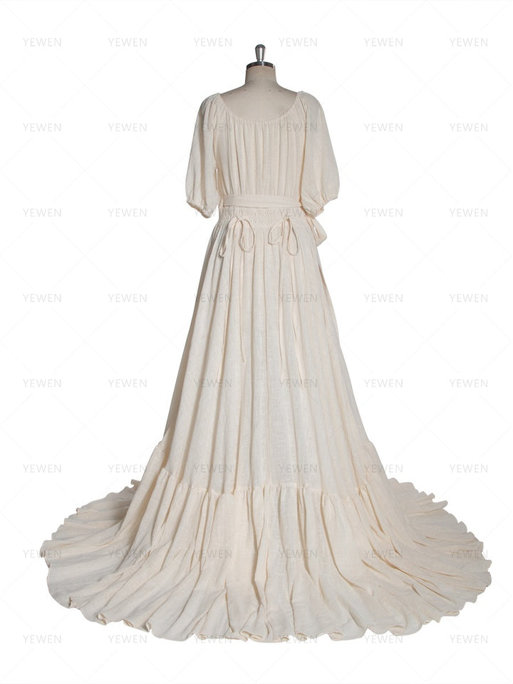 Back view of an ivory boho wrap maternity photoshoot dress with a deep V-neckline short sleeves and a flowing full skirt displayed on a mannequin.