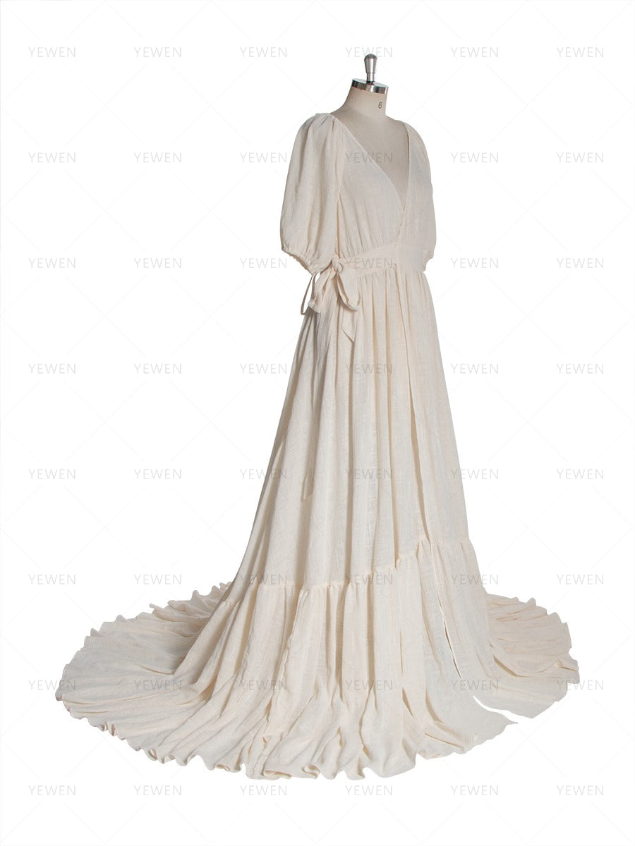 Side view of an ivory boho wrap maternity photoshoot dress with a deep V-neckline short sleeves and a flowing full skirt displayed on a mannequin.