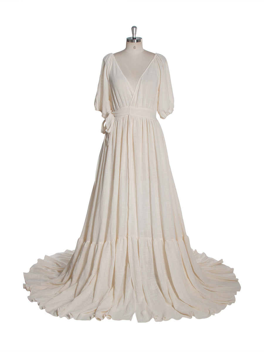 Front view of an ivory boho wrap maternity photoshoot dress with a deep V-neckline short sleeves and a flowing full skirt displayed on a mannequin.