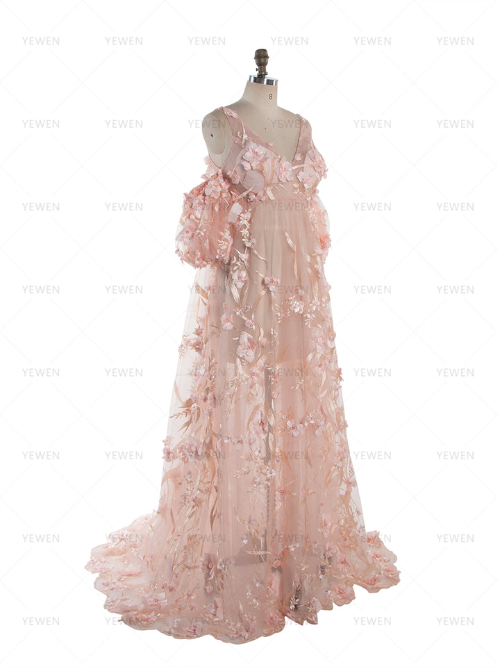 Side angle view of a light pink lace maternity photoshoot dress with 3D floral appliques and off-shoulder puffed sleeves, shown on a mannequin to highlight the flowing silhouette.