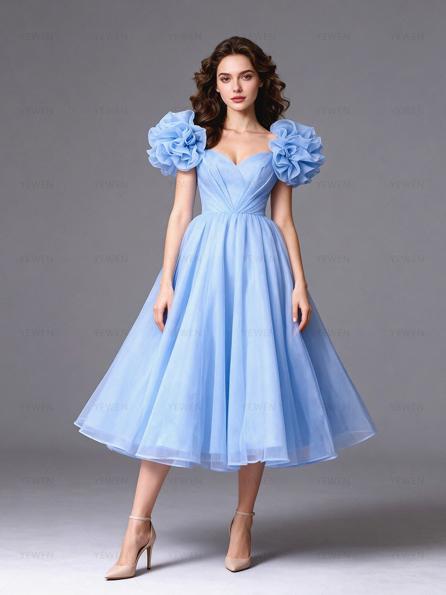 Full front view of a model wearing a light blue tulle A-line evening dress with puff sleeves and a sweetheart neckline.