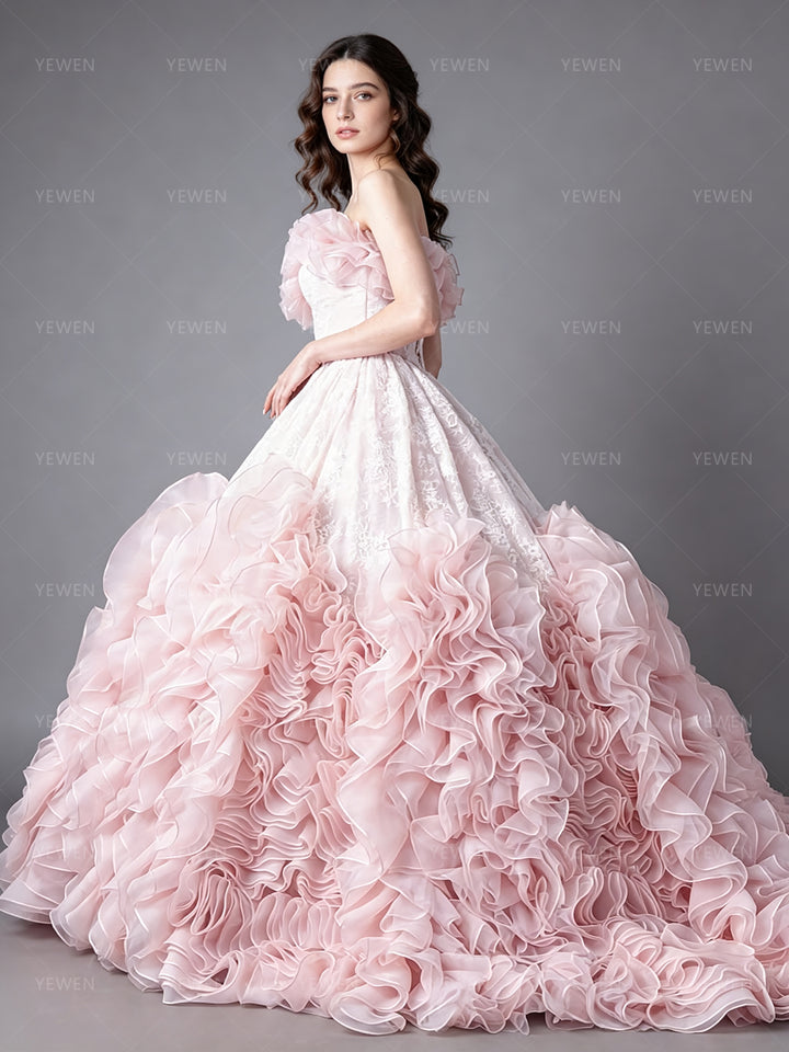 Side view of a gorgeous pink tulle ball gown featuring an off-the-shoulder ruffle neckline.