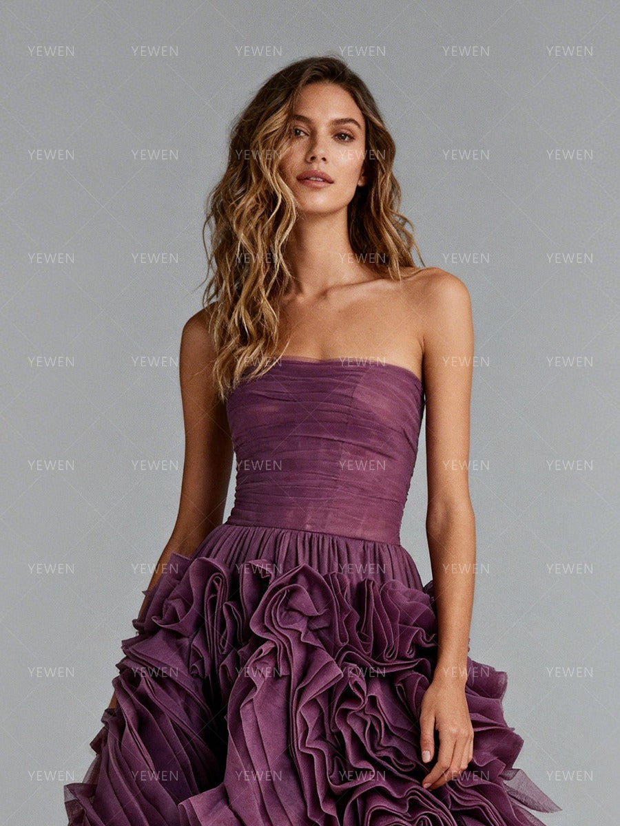Close-up front view of a model wearing a plum strapless prom dress highlighting the ruched bodice and 3D floral details.