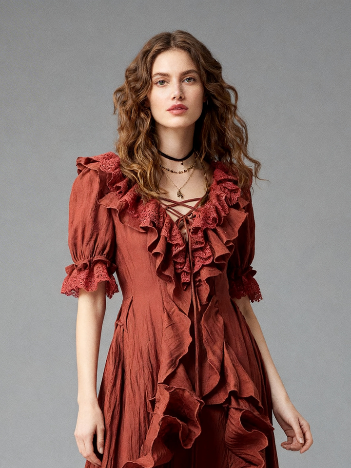 Close-up front view of a model wearing a rust boho ruffle dress highlighting the criss-cross tie V-neckline and layered ruffle trim.