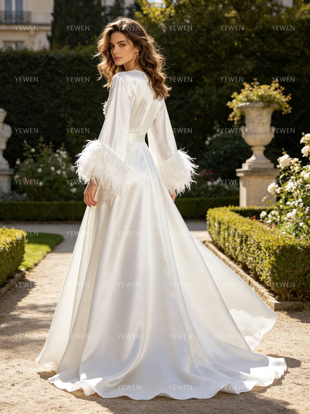 Luxury bridal robe back view featuring long white train and feathered sleeves.