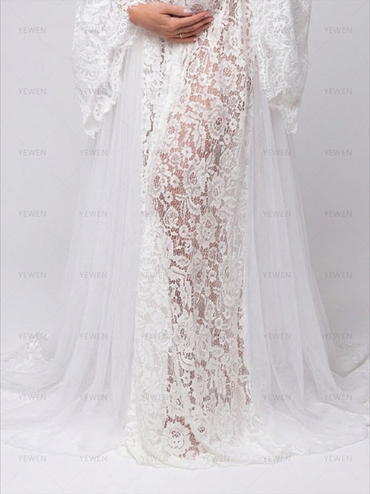Close-up of white lace maternity dress showing transparent fabric and a beautiful sweeping train.