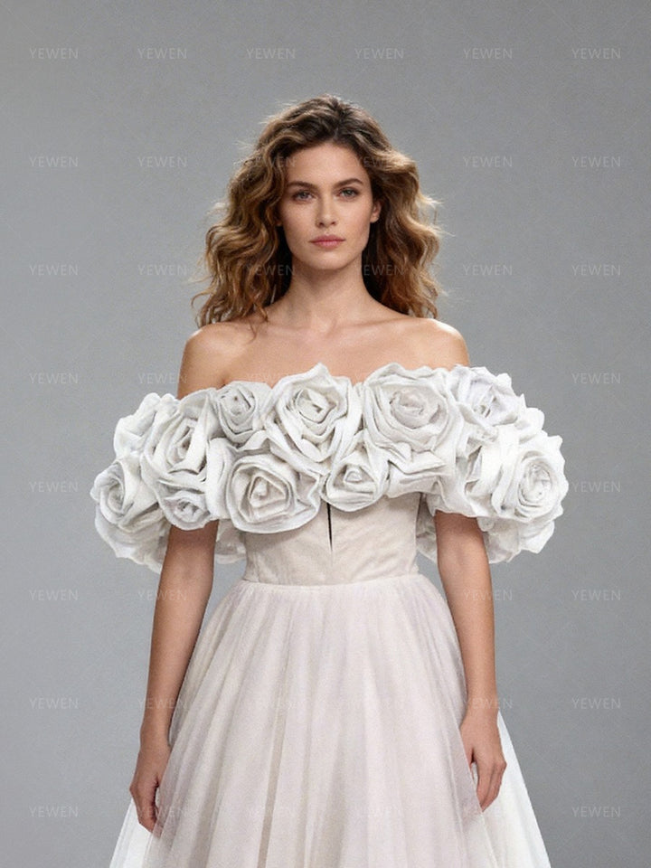 Close-up front view of a model wearing a white off-shoulder tulle gown highlighting the sweetheart neckline and 3D floral details.