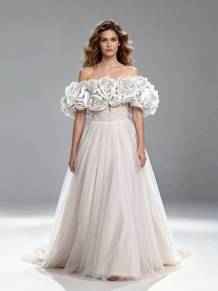 Full front view of a model wearing a white off-shoulder tulle gown with 3D floral details and a flowing A-line skirt.