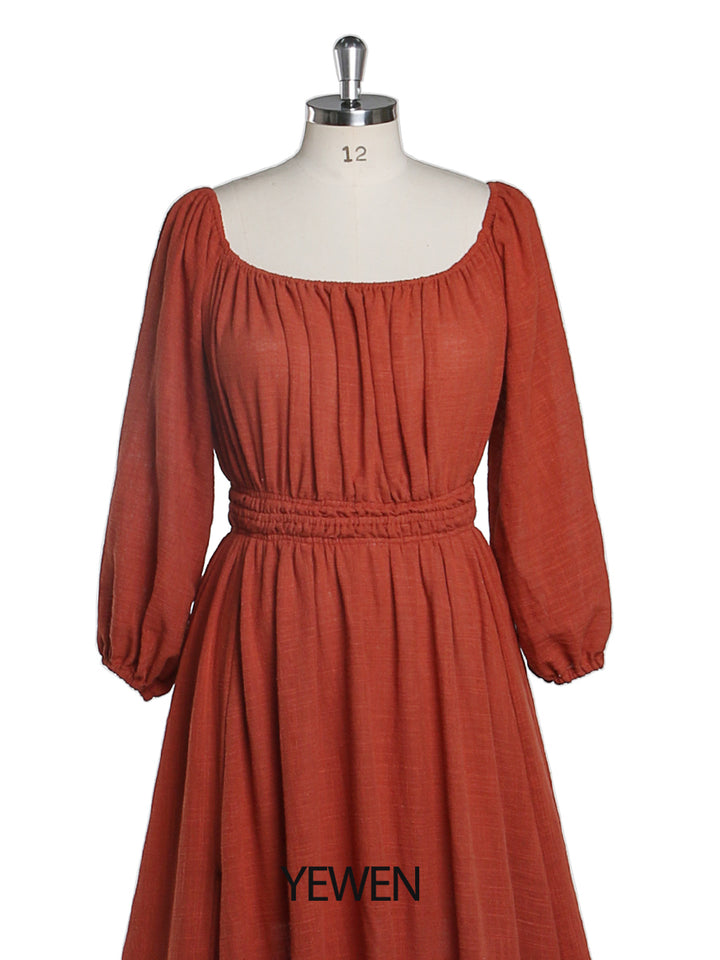 Close-up of rust round neck and full sleeves detail on boho maternity photoshoot dress showing soft elegant fabric