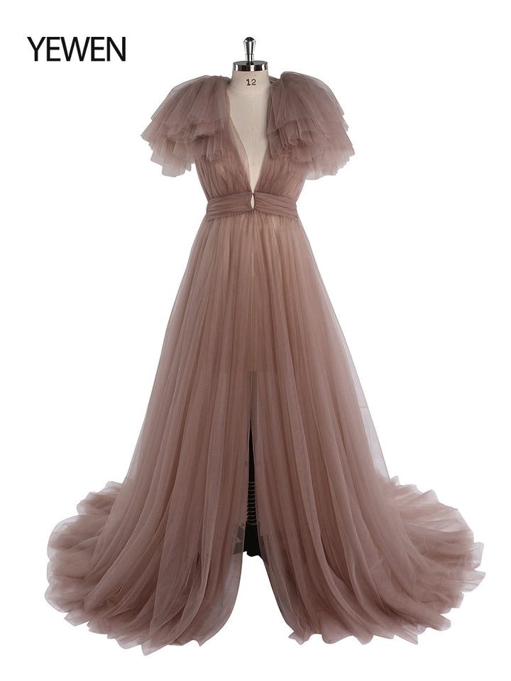 Front view of green maternity dress for photo shoot featuring tulle flowers and elegant flowing maxi design
