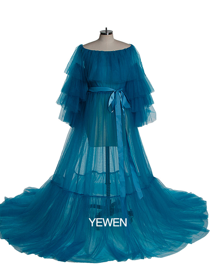 Front view of blue plus size maternity photoshoot dress featuring off shoulder ruffled design and flowing maxi silhouette