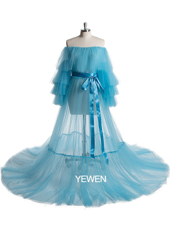 Front view of blue plus size maternity photoshoot dress featuring off shoulder ruffled design and flowing maxi silhouette