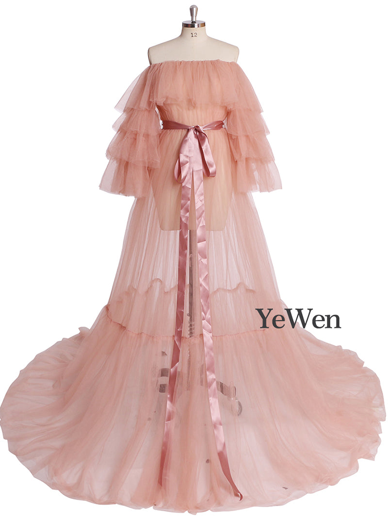 Front view of pink plus size maternity photoshoot dress featuring off shoulder ruffled design and flowing maxi silhouette