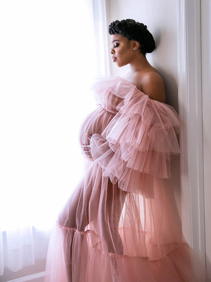 Elegant plus size maternity photoshoot dress styled in soft light with romantic ruffled see through design
