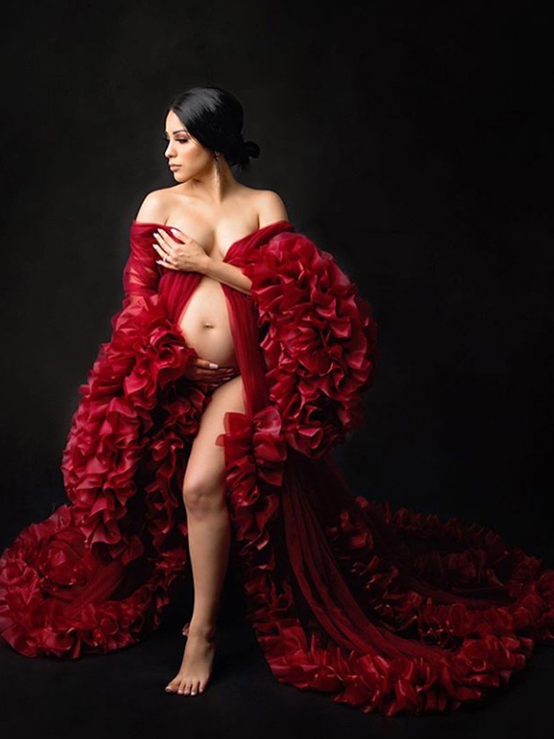 Woman wearing sexy photoshoot dress in elegant studio setting with ruffled design