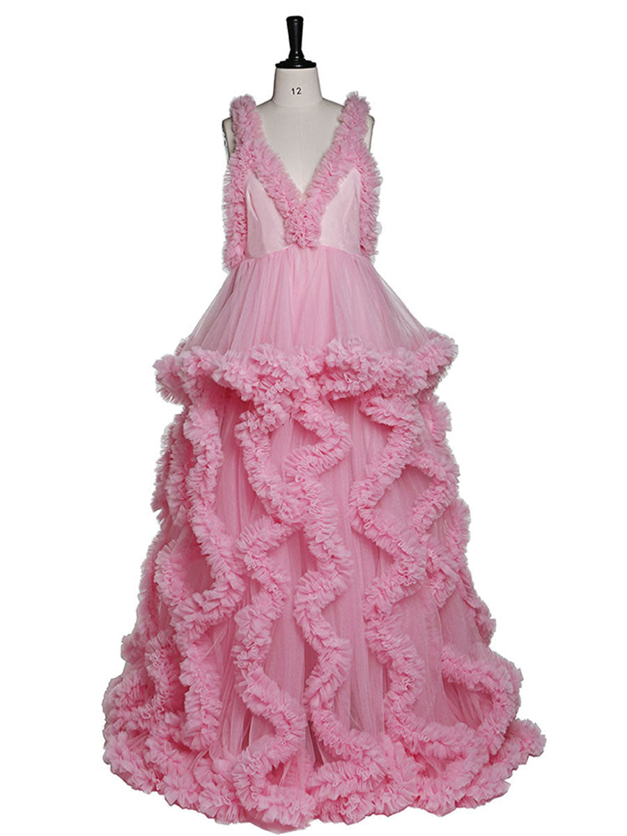 Front view of pink sleeveless maternity dress for photoshoot featuring elegant ruffle design and flowing silhouette