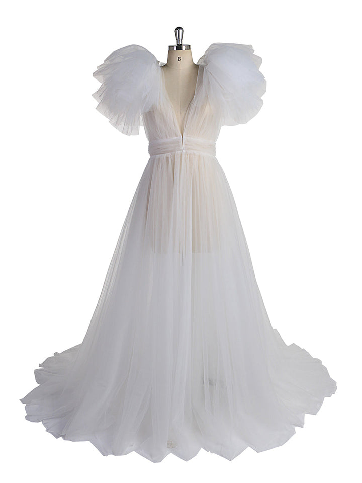 Front view of white maternity dress for photo shoot featuring tulle flowers and elegant flowing maxi design