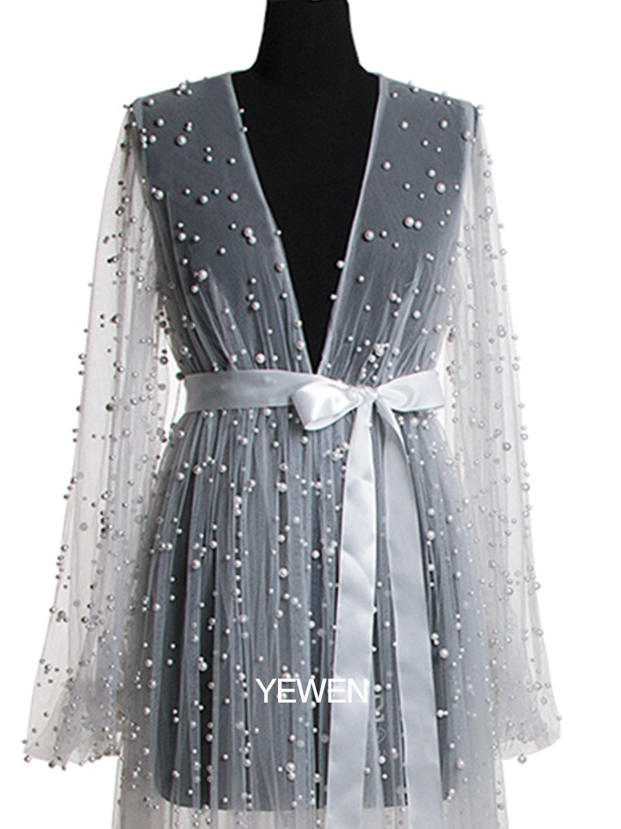 Close-up of pearl embellishment and fabric texture on white maternity photoshoot dress