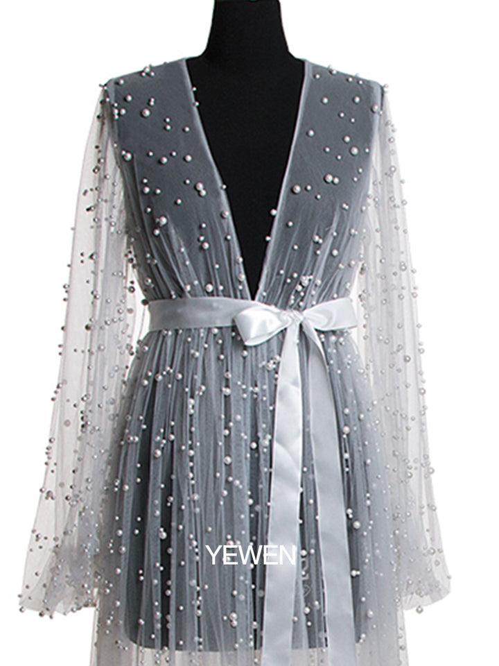 Close-up of pearl embellishment and fabric texture on white maternity photoshoot dress